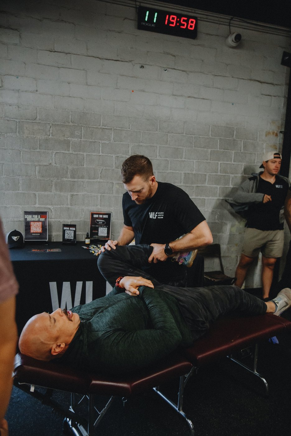 A WLF staff member working on a client lying on a treatment table.