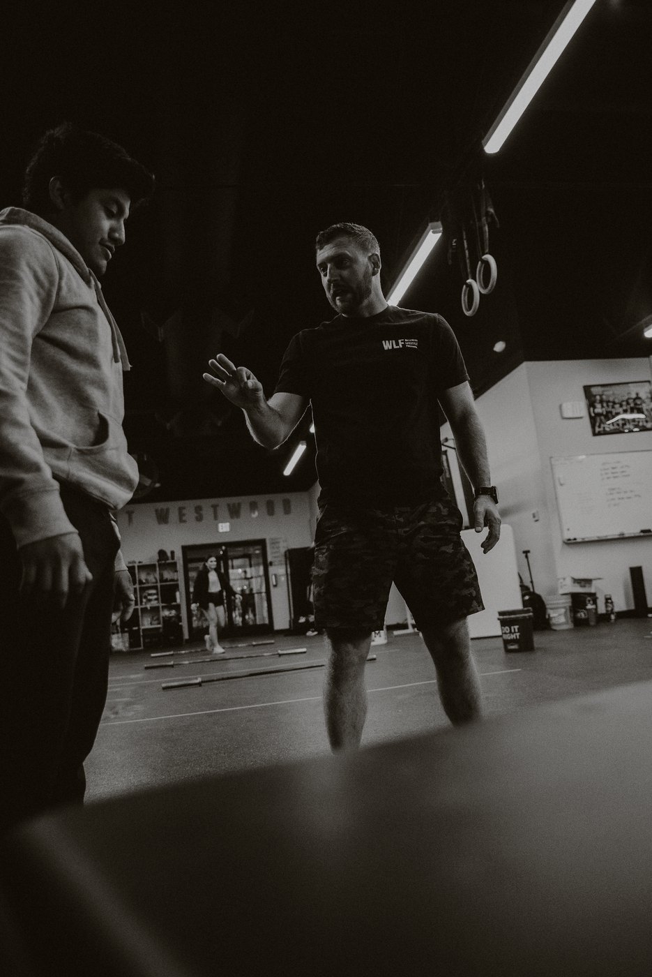 A WLF trainer coaching a member on the training floor.